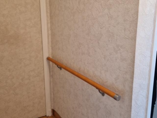Main-courante en bois installée pour sécuriser un couloir