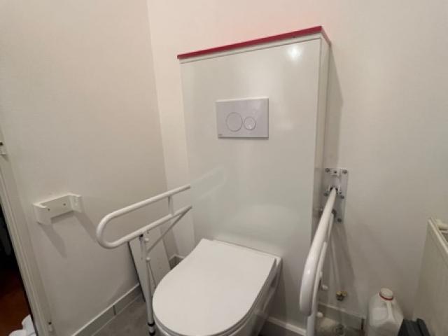 Pose d'un WC surélevé suspendu avec des barres de maintien sur pied à Nantes - Apres