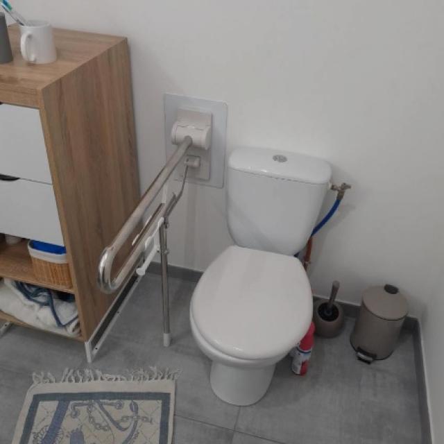 Pose d'une barre d'appui relevable sur pied à côté des toilettes 